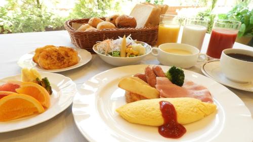 a table with plates of breakfast foods and drinks at Hotel Precede Koriyama in Koriyama