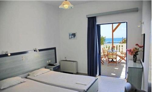 a bedroom with a bed and a view of a patio at Sky Beach Hotel in Agia Galini