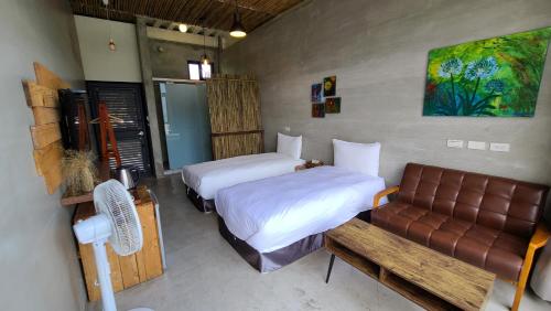 a bedroom with two beds and a couch in it at 達芭凱民宿 Tabakai B&B in Xinyi