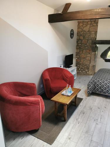 a living room with two chairs and a coffee table at La Chambre de La Pomerie in Chiché