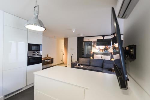 uma cozinha e sala de estar com um balcão branco em Apartament EXCLUSIVE FYRTEL WILDA - NEW em Poznań