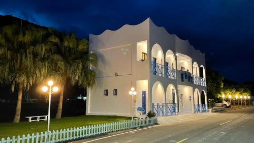 a white building with lights on the side of a street at Blue and White Style Holiday B&B in Guanshan