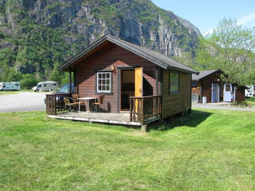 a small cabin with a deck with a table at Sæbø Camping in Eidfjord