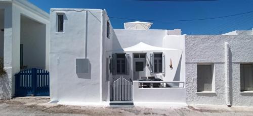 a white house with a gate in front of it at Casa Nostalgia in Adamas