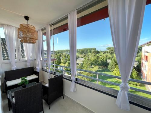a room with windows with a view of a river at Chance Apartman Bükfürdő in Bük
