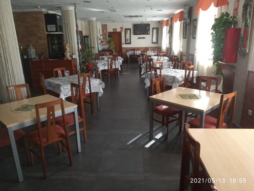 een eetkamer met tafels en stoelen in een restaurant bij Olimpia Hoteles in Totana