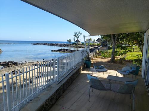 a porch with chairs and a view of the beach at Les 2 canons in Flic-en-Flac