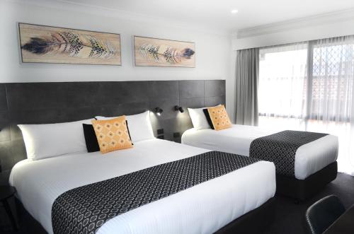 a hotel room with two beds and a window at Orana Motel in Dubbo