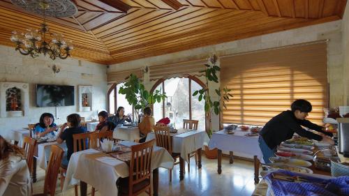 a group of people sitting at tables in a restaurant at Harman Cave Hotel in Goreme