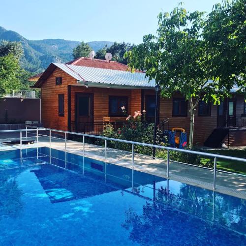 a house with a swimming pool in front of a house at yenivadi in Antalya