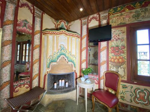 a living room with a fireplace and a tv at Archontika Karamarlis in Makrinitsa