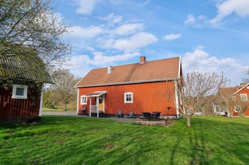 an orange barn with a grassy yard at Fully equipped house in the countryside at Knohult in Aneby