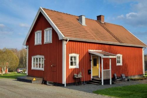 a red house with a yellow door at Fully equipped house in the countryside at Knohult in Aneby