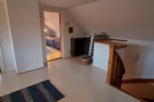 an attic room with a staircase and a bedroom at Fully equipped house in the countryside at Knohult in Aneby