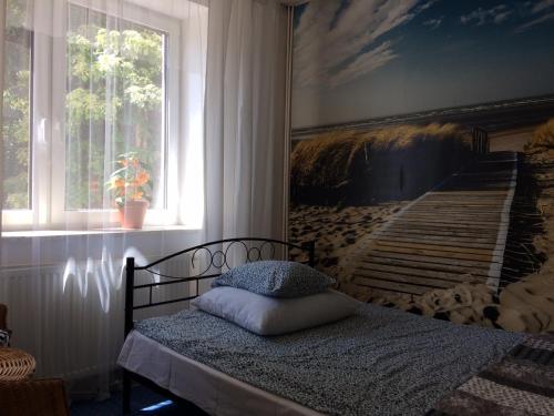 a bedroom with a bed with a painting on the wall at Rybacka 38 in Kąty Rybackie