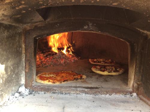 two pizzas are cooking in a brick oven at Art & Breakfast in Ripabottoni