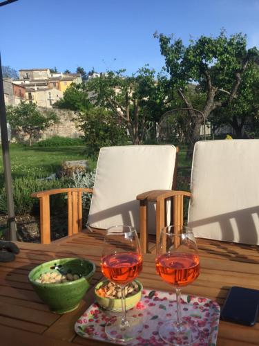 a wooden table with two glasses of wine on it at Art & Breakfast in Ripabottoni