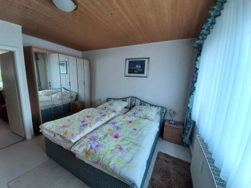 sypialnia z łóżkiem i lustrem w obiekcie Ferienwohnung Waldblick Oberhof w mieście Oberhof