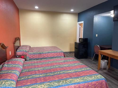 a hotel room with a bed and a table at Kenwood Court Motel in Wilson