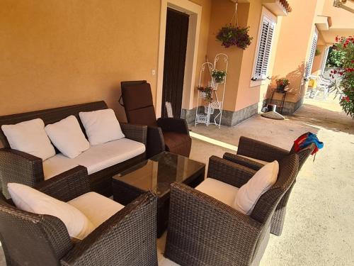a living room with wicker chairs and a couch at Apartments Jela in Metajna