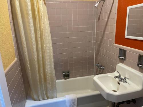a bathroom with a sink and a toilet and a tub and a sink at Kenwood Court Motel in Wilson
