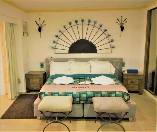 a bedroom with a bed with two chairs in it at Jasmin 4 in Netanya