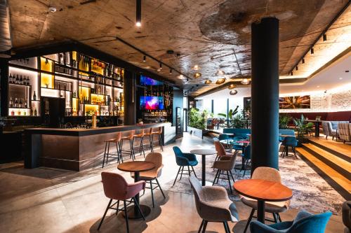 布拉格OREA Hotel Pyramida Praha的有桌椅和酒吧的餐厅