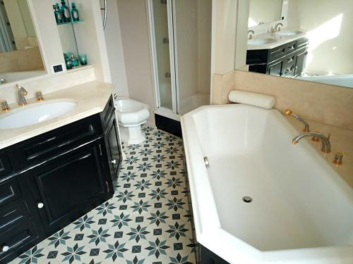 Un baño con bañera, lavabo e inodoro. en Villa Eva des landes, en Rion-des-Landes