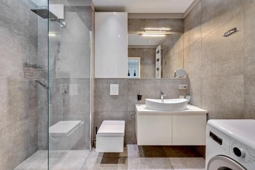 a bathroom with a sink and a toilet and a shower at Luxury Bianco Apartament in Sopot