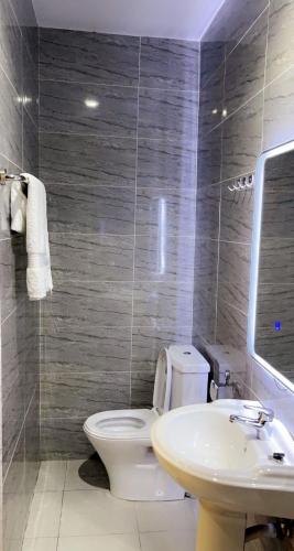 a bathroom with a toilet and a sink at Bonsukoda Lodge in Accra