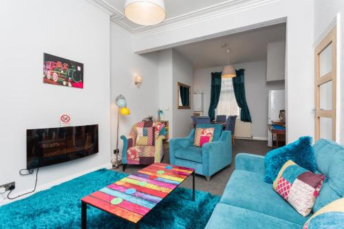 a living room with blue furniture and a fireplace at Langan's Blackpool Holiday Let in Blackpool
