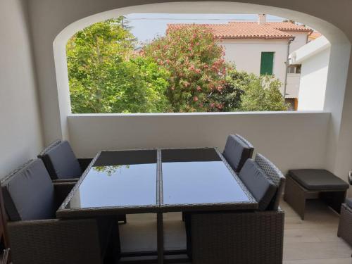 a table and chairs on a balcony with a window at La casa di Laura in Tortolì