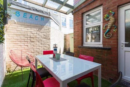 a white table and red chairs on a patio at Langan's Blackpool Holiday Let in Blackpool