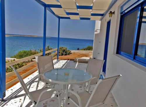 a table and chairs on a balcony with the ocean at Sea View Holiday House in Archangelos