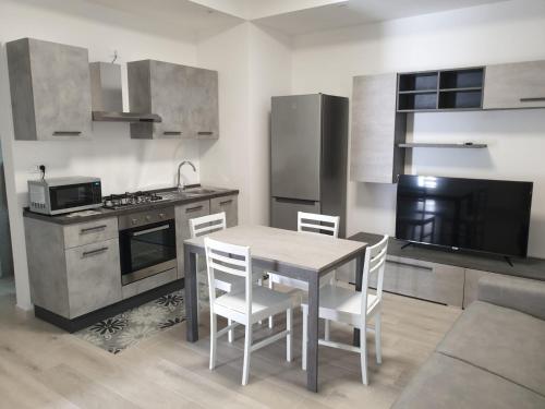 a kitchen with a table and chairs in a room at La casa di Laura in Tortolì