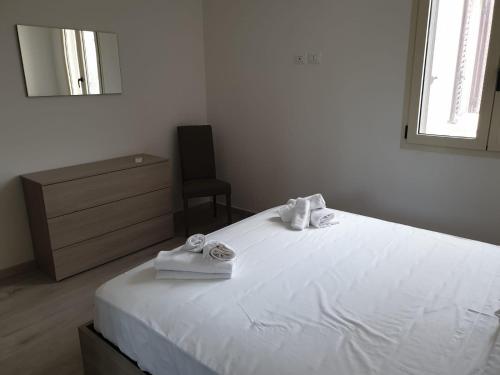 a bedroom with a white bed with towels on it at La casa di Laura in Tortolì