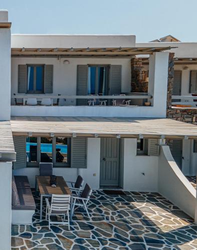 a balcony of a house with a table and chairs at Anemos in Parikia