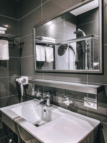 a bathroom with a white sink and a mirror at Hotel Arifi in Shkodër