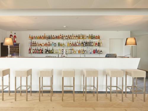 a bar with four stools in front of a counter at Hotel AVA in Sempach Station