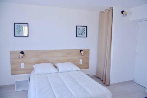 a bedroom with a large white bed with two pillows at Les Forges studio étage in Avoine