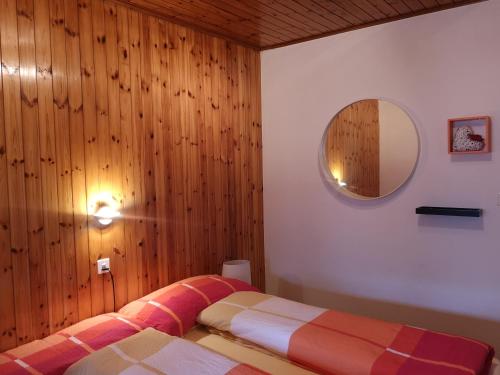 1 dormitorio con 1 cama y pared de madera en Aletschblick, en Grächen
