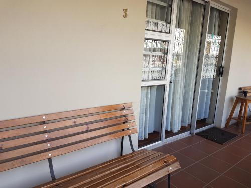 a wooden bench in a room with a window at Crane Cottage in Colesberg