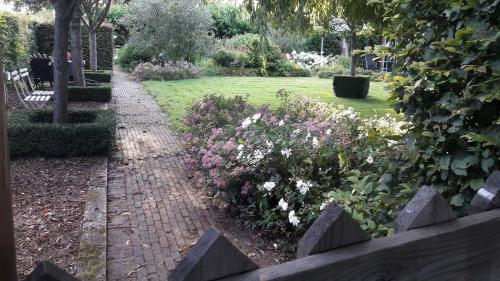 a garden with a brick path and flowers at Roing B&B in Hijken