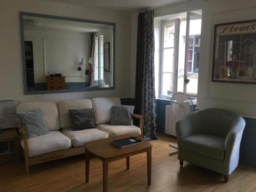 a living room with a couch and a chair and a table at Le studio de St-Sauveur in Dinan