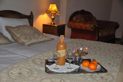 a tray with a bottle of wine and glasses on a bed at Hotel Samarkand Safar in Samarkand