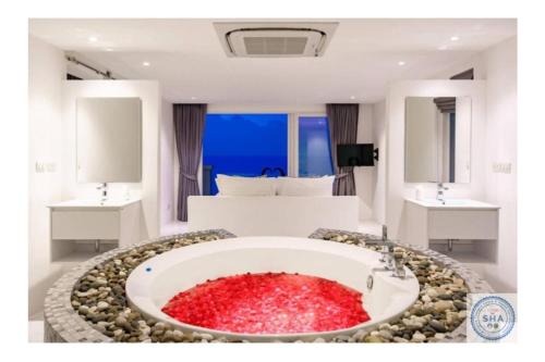 una habitación con una gran bañera llena de rocas rojas en Panorama Samui Residences en Ban Bang Po