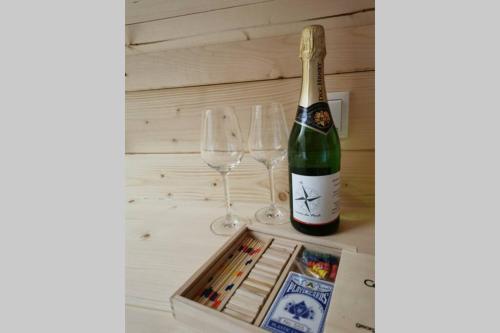 una botella de champán y dos copas de vino en una mesa en Heksenhuis, en Goebelsmuhle