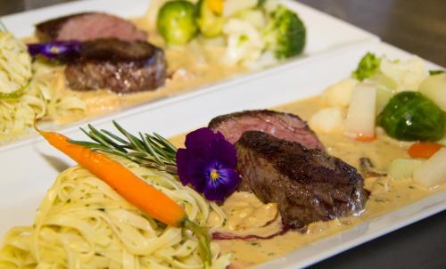 a plate of food with noodles and meat and vegetables at Hotel Hubertus in Sankt Johann im Pongau