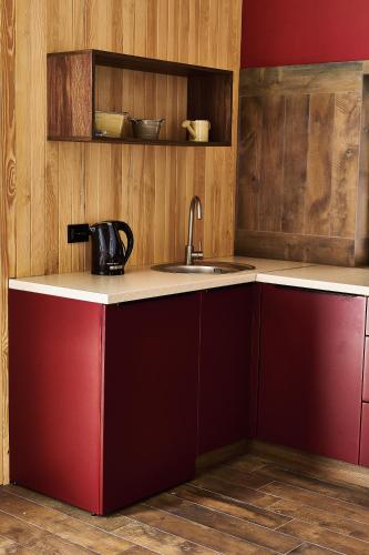 a kitchen with red cabinets and a sink at WindRose in Zatoka