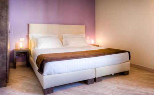 a bedroom with a large white bed with two lamps at Forte16 View & SPA in Florence